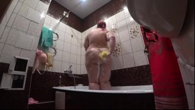 Behind the scenes, a hidden camera is spying on a fat porn model with a big ass in the bathroom.